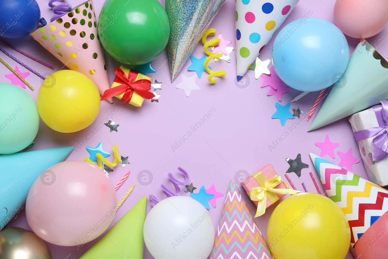 Beautiful party hats and other festive decor on lilac background, flat lay. Space for text Photo of Beautiful party hats and other festive decor on lilac background, flat lay. Space for text