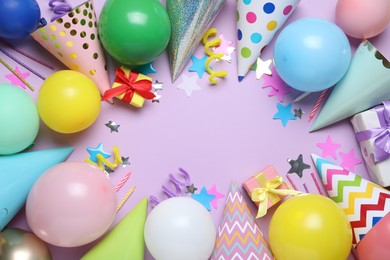 Photo of Beautiful party hats and other festive decor on lilac background, flat lay. Space for text