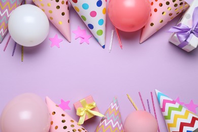 Photo of Beautiful party hats and other festive decor on lilac background, flat lay. Space for text