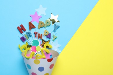 Photo of Beautiful party hat, topper and confetti on color background, flat lay. Space for text