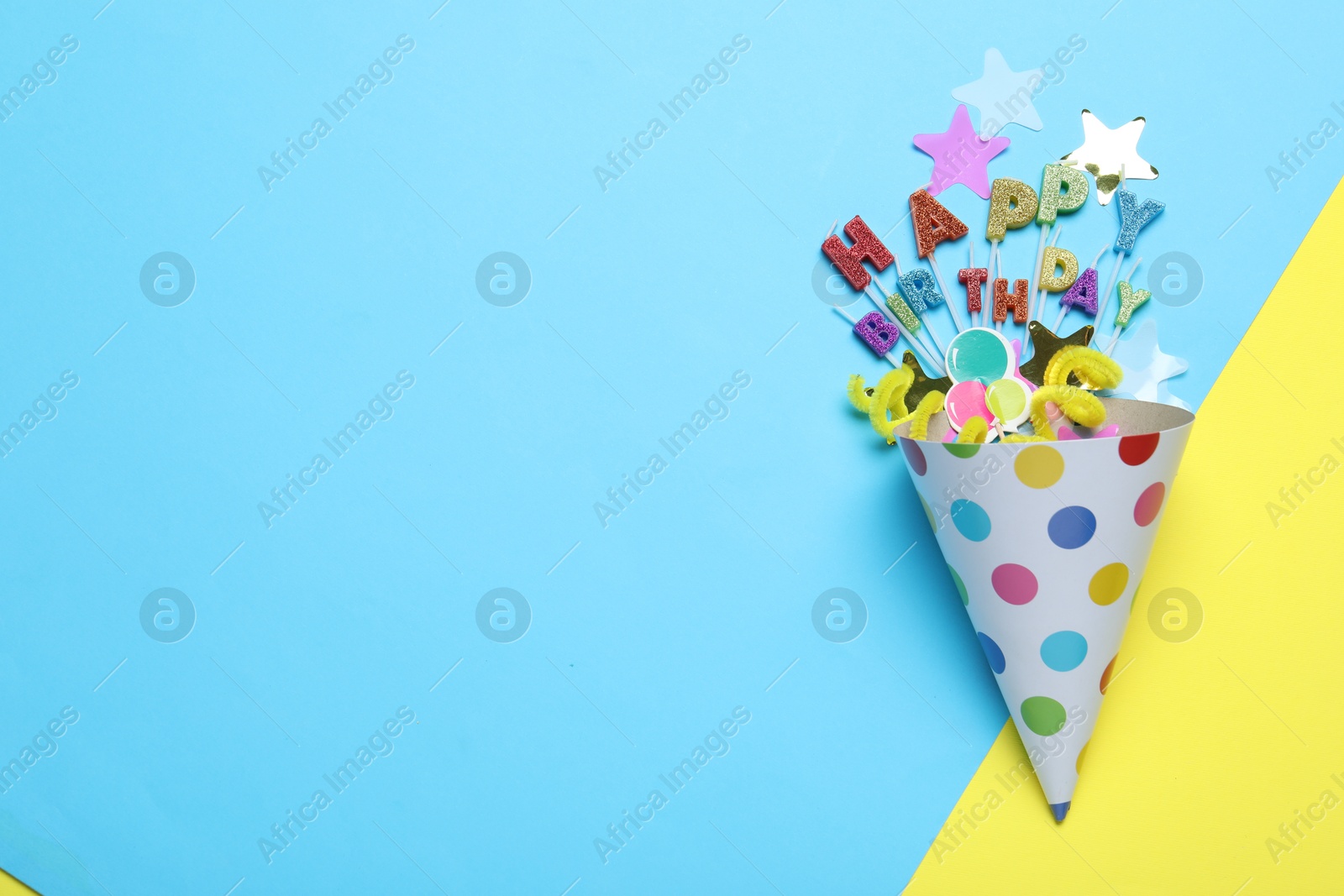 Beautiful party hat, topper and confetti on color background, flat lay. Space for text Photo of Beautiful party hat, topper and confetti on color background, flat lay. Space for text