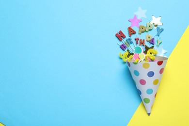 Photo of Beautiful party hat, topper and confetti on color background, flat lay. Space for text