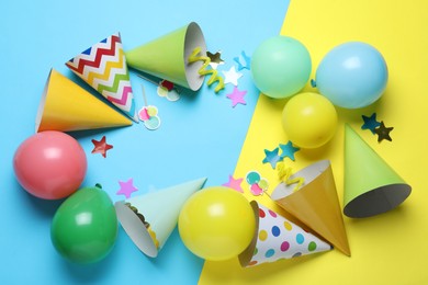 Photo of Beautiful party hats and other festive decor on color background, flat lay. Space for text