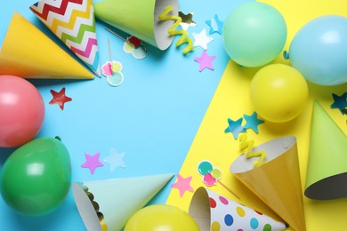 Photo of Beautiful party hats and other festive decor on color background, flat lay. Space for text