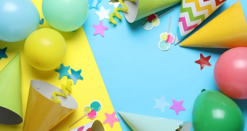 Photo of Beautiful party hats and other festive decor on color background, flat lay. Space for text