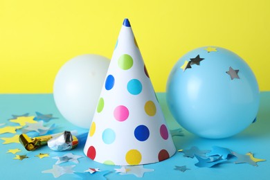 Photo of Beautiful party hat and other festive decor on color background