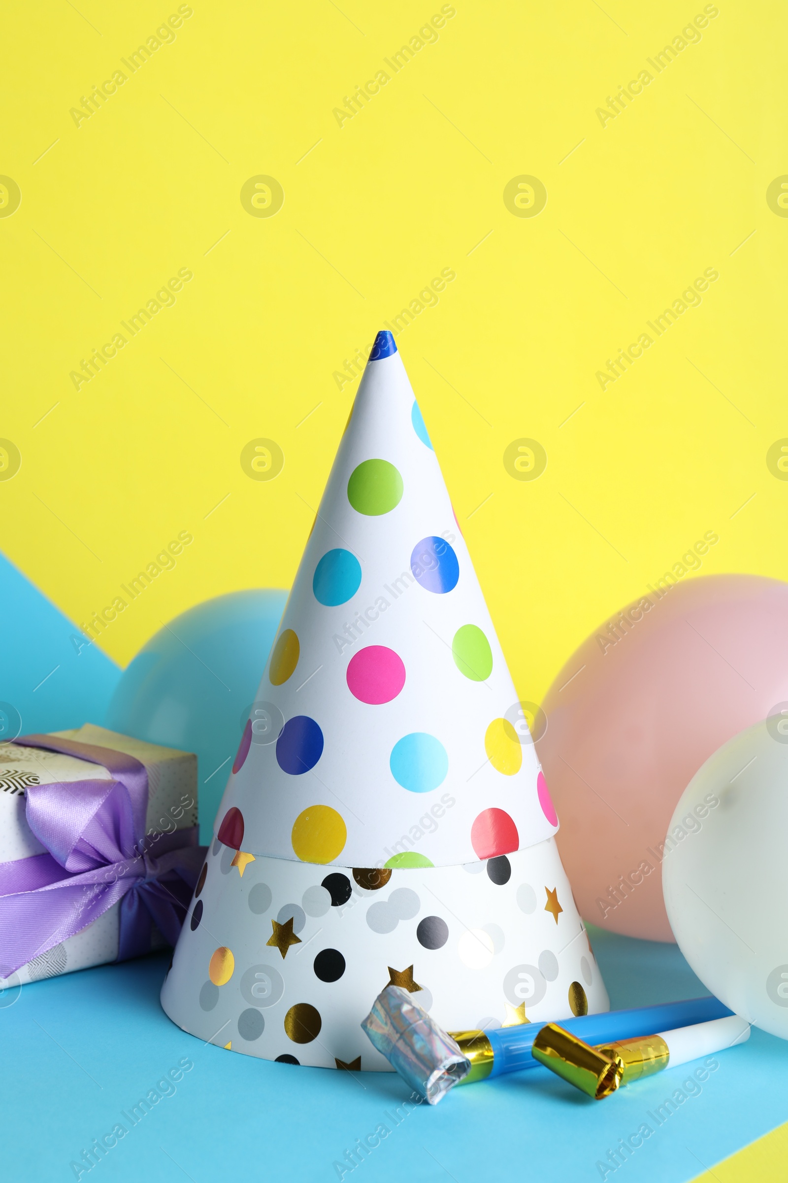 Beautiful party hats and other festive decor on color background Photo of Beautiful party hats and other festive decor on color background