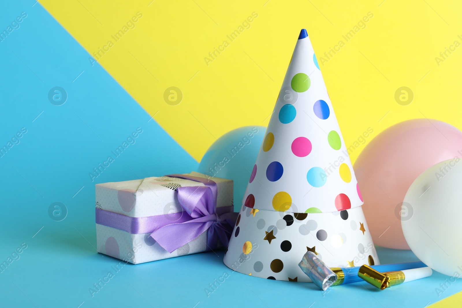 Beautiful party hats and other festive decor on color background Photo of Beautiful party hats and other festive decor on color background