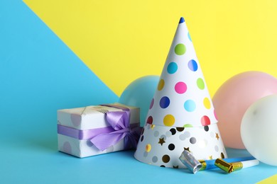 Photo of Beautiful party hats and other festive decor on color background