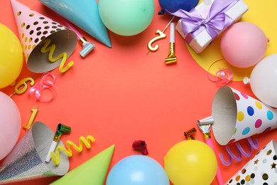 Photo of Beautiful party hats and other festive decor on red background, flat lay. Space for text