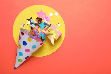 Photo of Beautiful party hat and other festive decor on red background, flat lay. Space for text