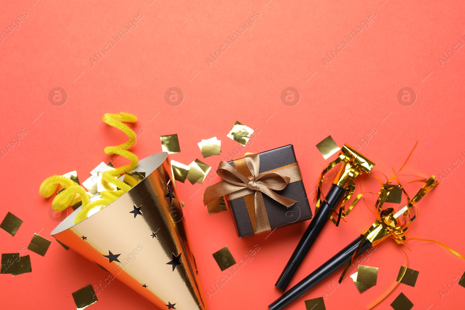 Beautiful party hat and other festive decor on red background, flat lay. Space for text Photo of Beautiful party hat and other festive decor on red background, flat lay. Space for text