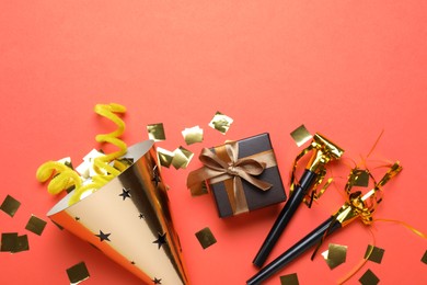 Photo of Beautiful party hat and other festive decor on red background, flat lay. Space for text