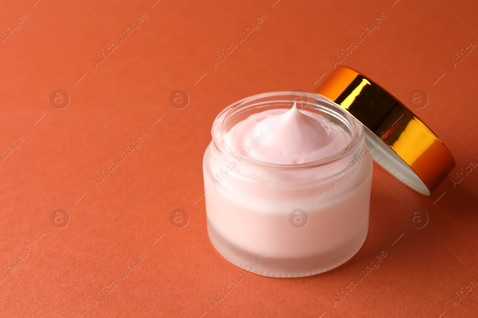 Jar of moisturizing body cream on orange background, closeup. Space for text Photo of Jar of moisturizing body cream on orange background, closeup. Space for text