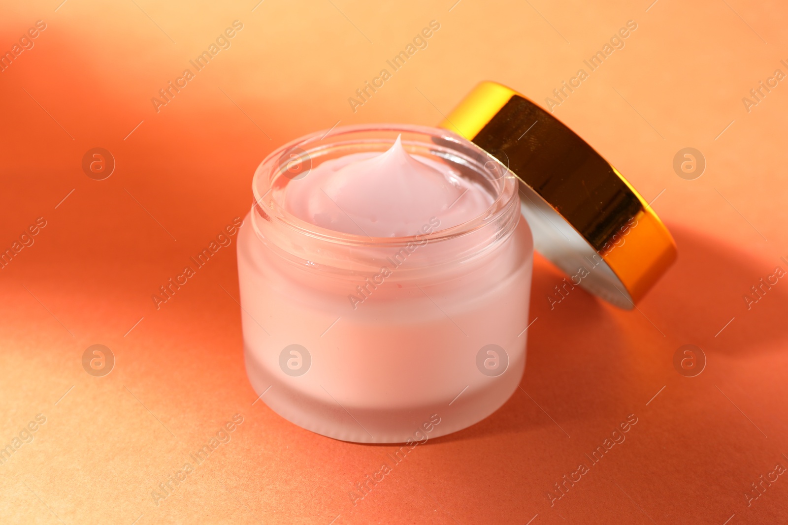Jar of moisturizing body cream on orange background, closeup Photo of Jar of moisturizing body cream on orange background, closeup
