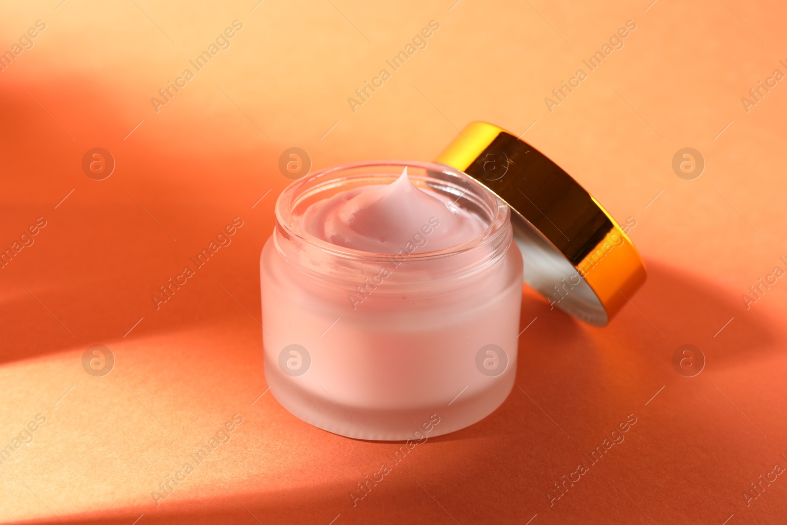 Jar of moisturizing body cream on orange background, closeup Photo of Jar of moisturizing body cream on orange background, closeup