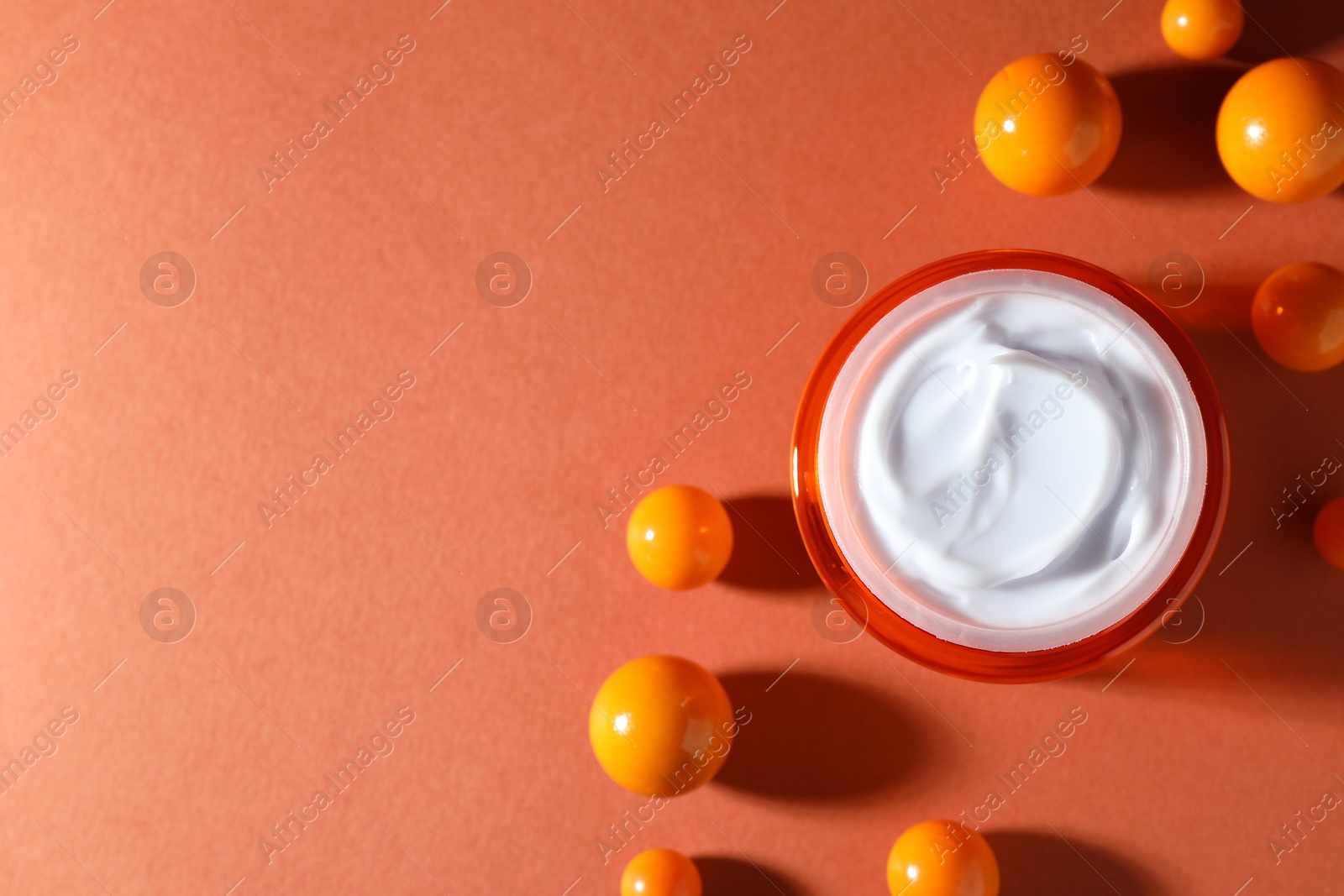 Jar of moisturizing body cream and balls on orange background, flat lay. Space for text Photo of Jar of moisturizing body cream and balls on orange background, flat lay. Space for text
