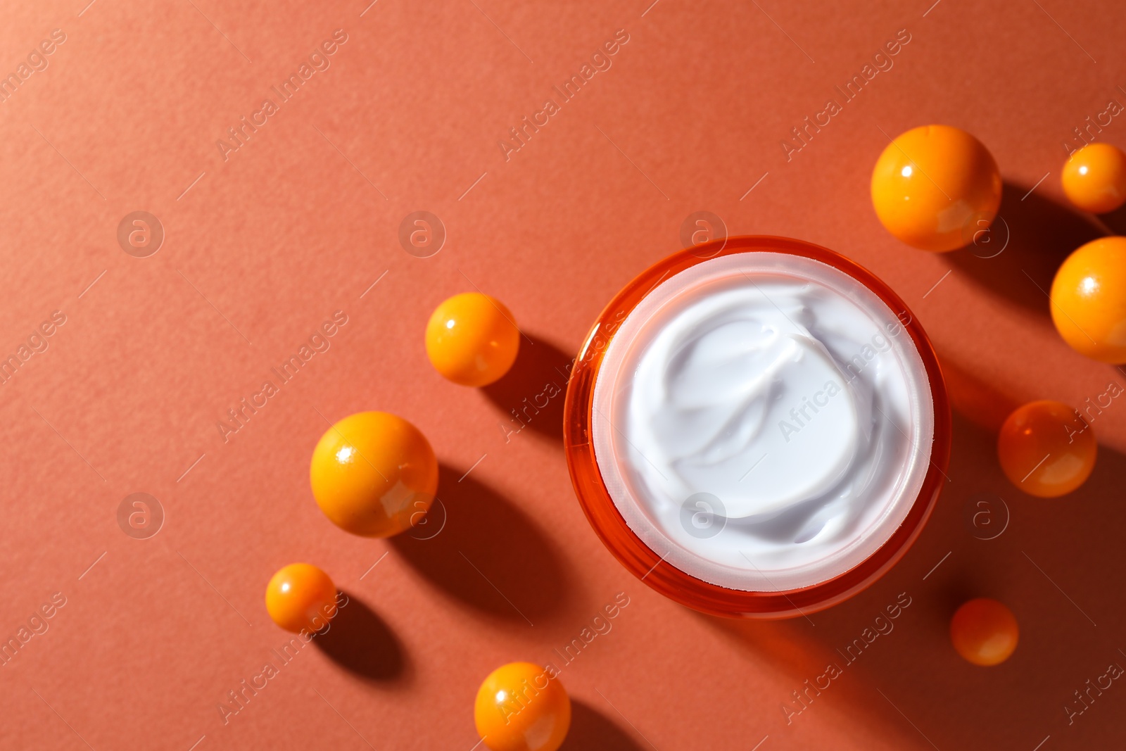 Jar of moisturizing body cream and balls on orange background, flat lay. Space for text Photo of Jar of moisturizing body cream and balls on orange background, flat lay. Space for text