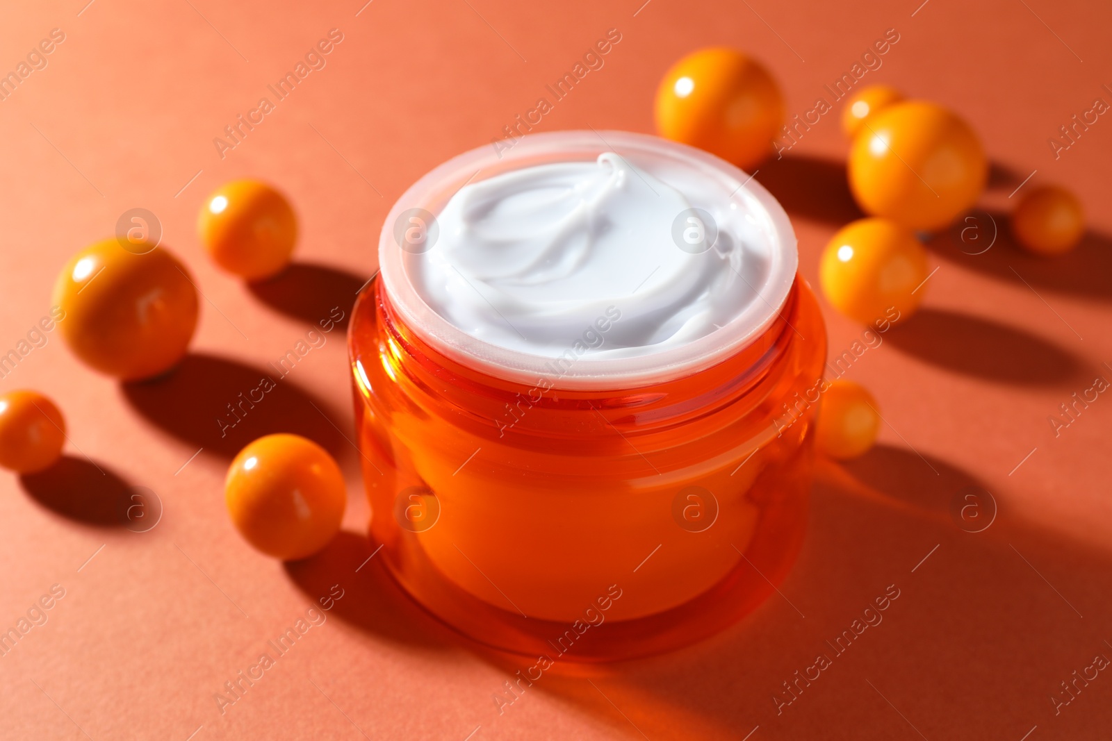 Jar of moisturizing body cream and balls on orange background, closeup Photo of Jar of moisturizing body cream and balls on orange background, closeup