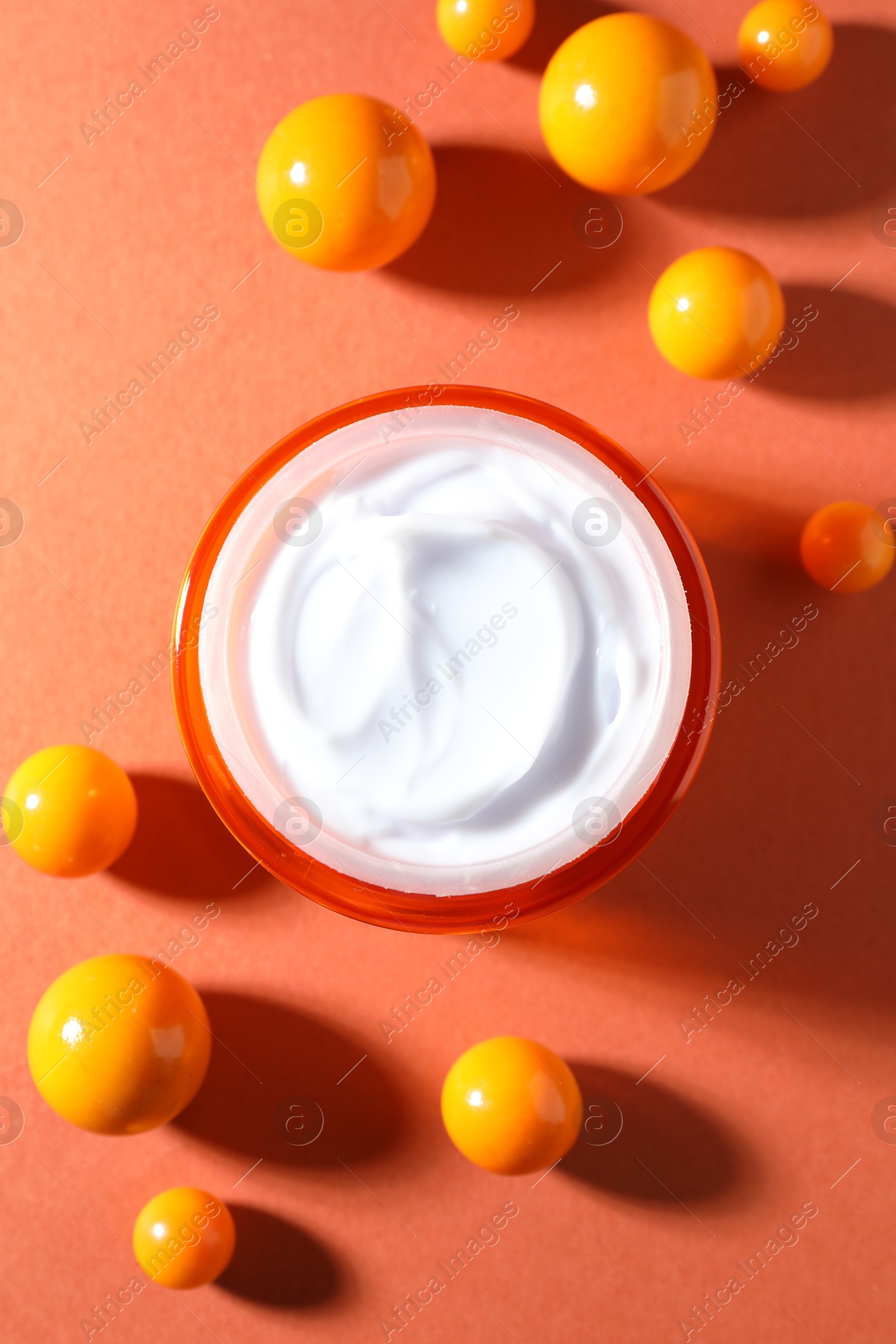 Jar of moisturizing body cream and balls on orange background, flat lay Photo of Jar of moisturizing body cream and balls on orange background, flat lay