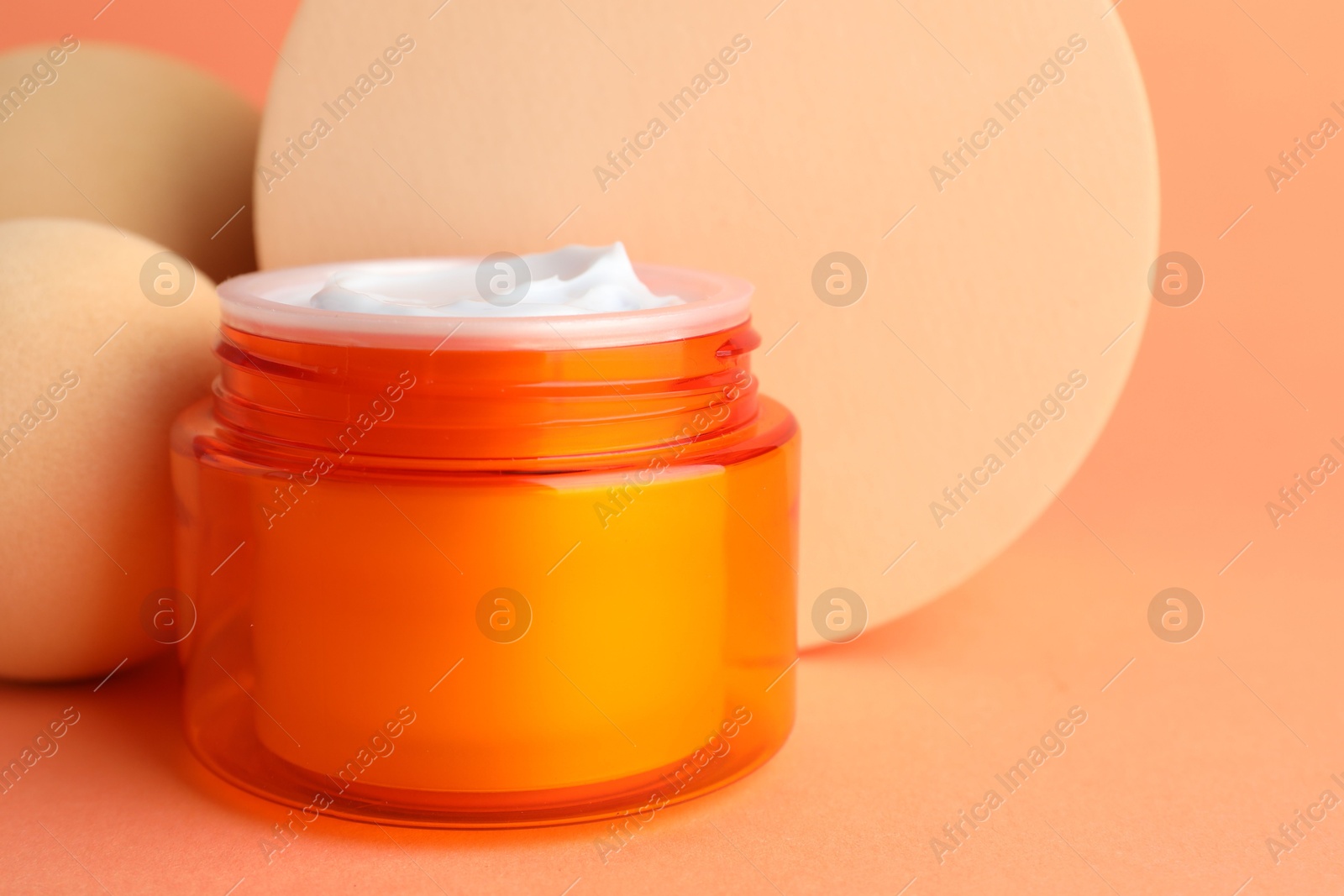 Stylish presentation of moisturizing body cream in jar on orange background, closeup. Space for text Photo of Stylish presentation of moisturizing body cream in jar on orange background, closeup. Space for text