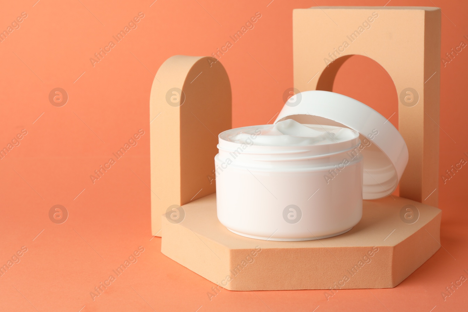 Stylish presentation of moisturizing body cream in jar on orange background, closeup. Space for text Photo of Stylish presentation of moisturizing body cream in jar on orange background, closeup. Space for text