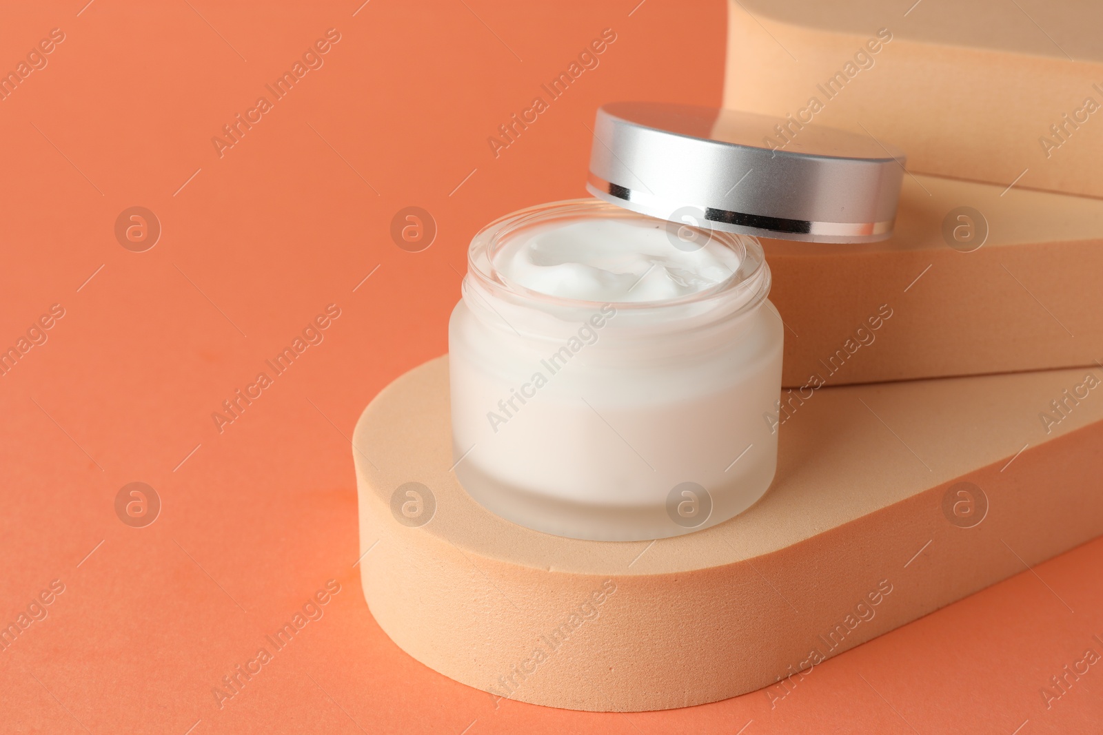 Stylish presentation of moisturizing body cream in jar on orange background, closeup. Space for text Photo of Stylish presentation of moisturizing body cream in jar on orange background, closeup. Space for text