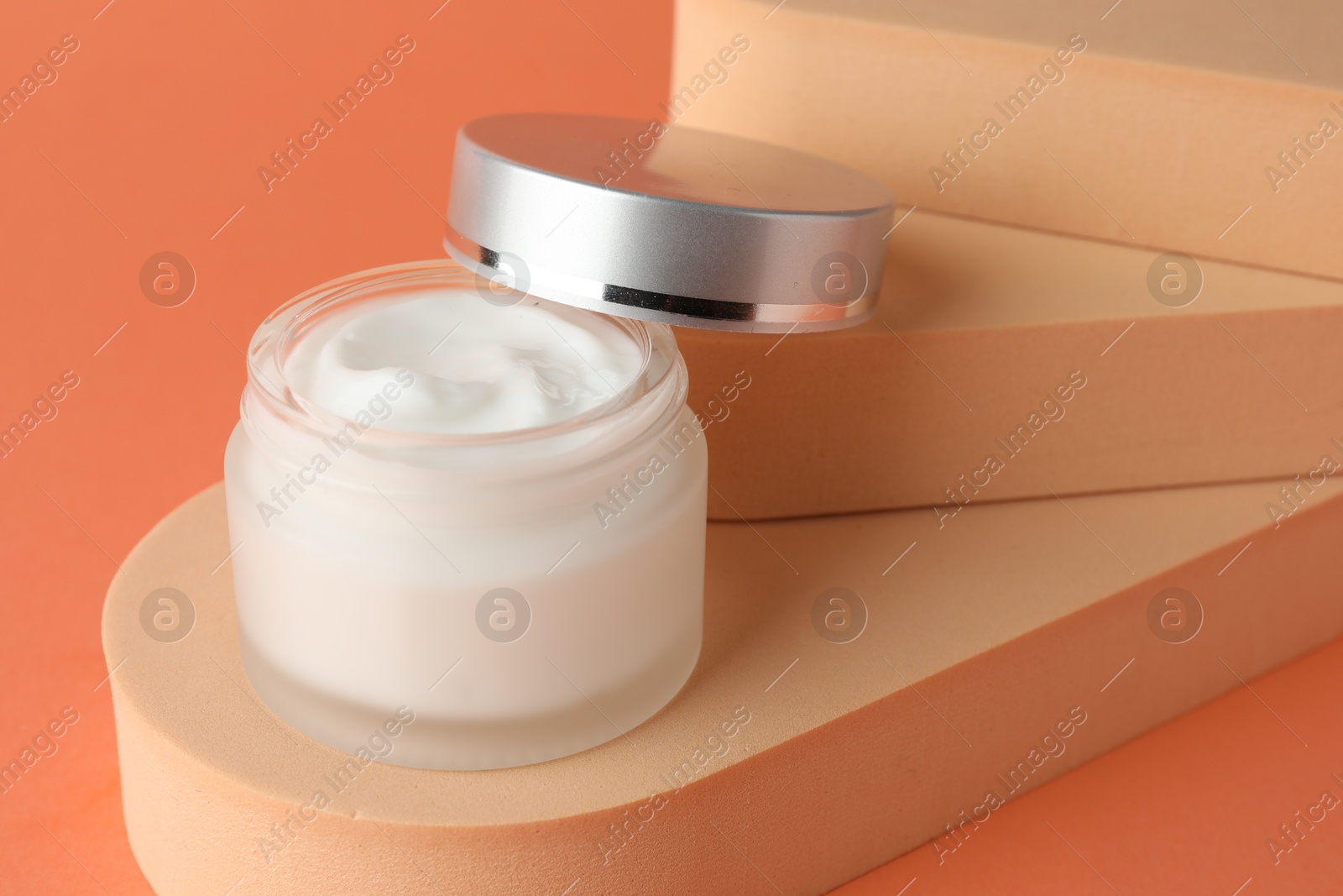 Stylish presentation of moisturizing body cream in jar on orange background, closeup Photo of Stylish presentation of moisturizing body cream in jar on orange background, closeup