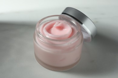 Photo of Jar of moisturizing body cream on white table, closeup