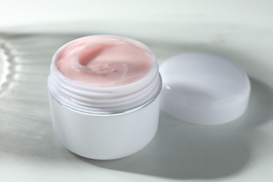 Photo of Jar of moisturizing body cream on white table, closeup