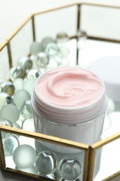 Photo of Jar of moisturizing body cream and glass tray on white table, closeup