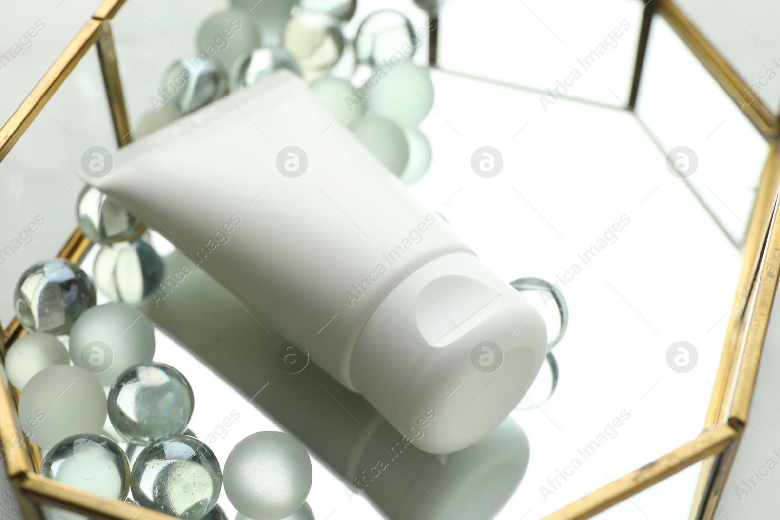 Tube of moisturizing body cream and glass tray on white table, closeup Photo of Tube of moisturizing body cream and glass tray on white table, closeup