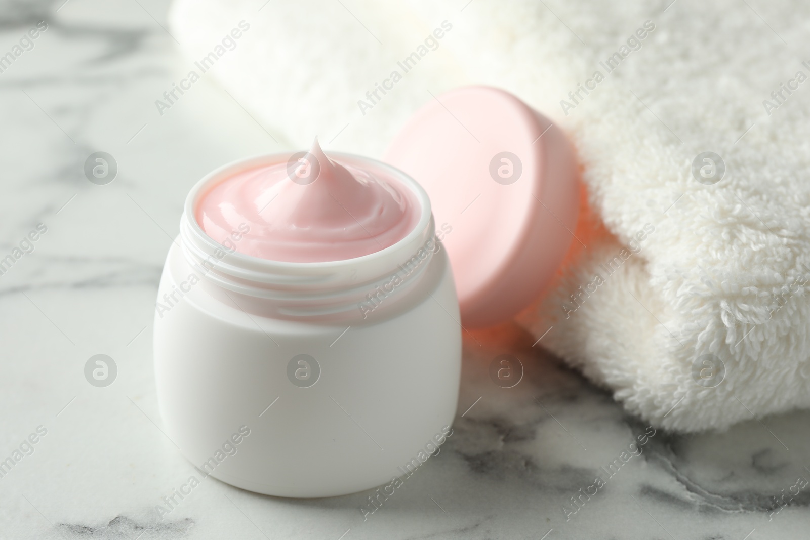 Jar of moisturizing body cream on white marble table, closeup Photo of Jar of moisturizing body cream on white marble table, closeup