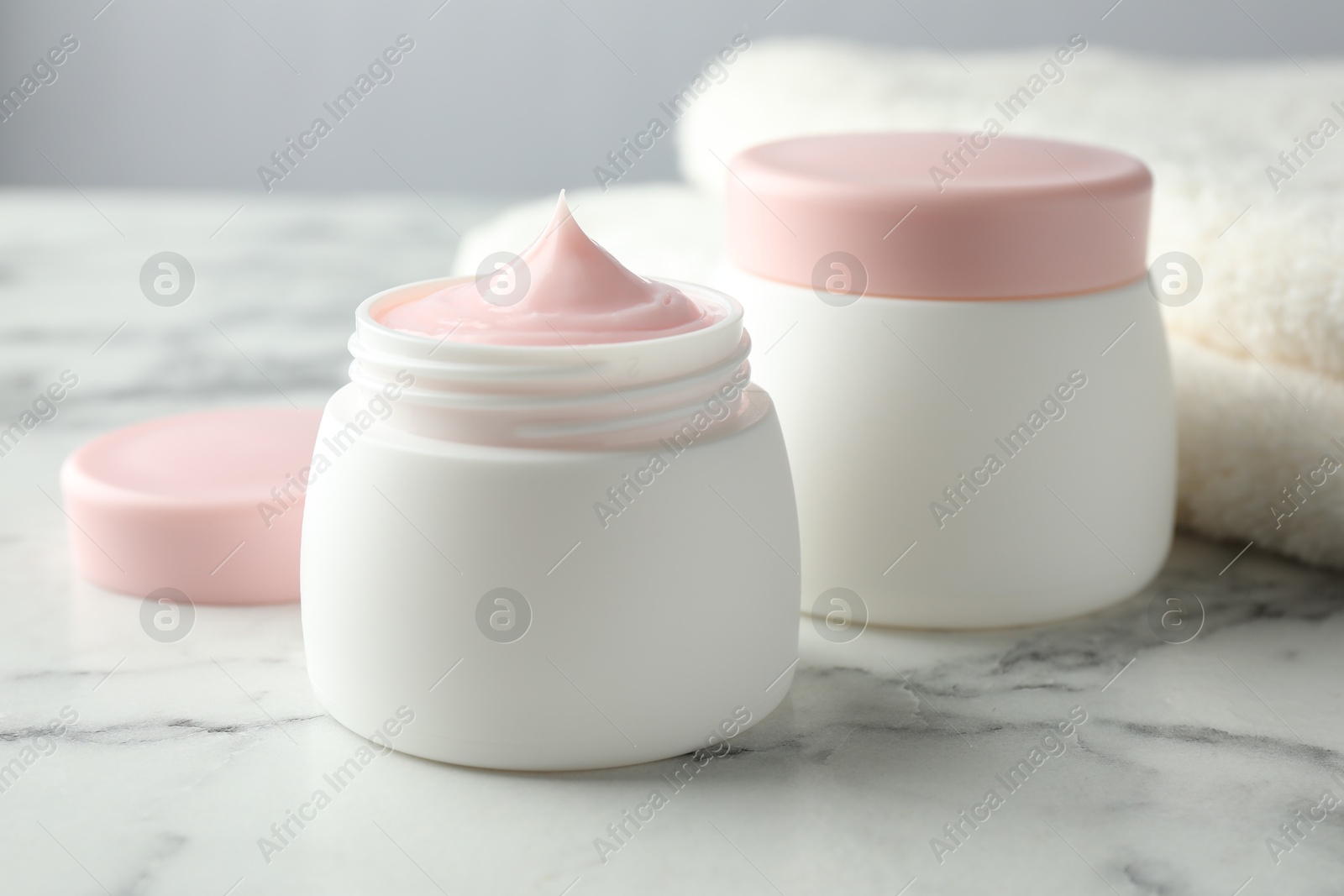 Jar of moisturizing body cream on white marble table, closeup Photo of Jar of moisturizing body cream on white marble table, closeup