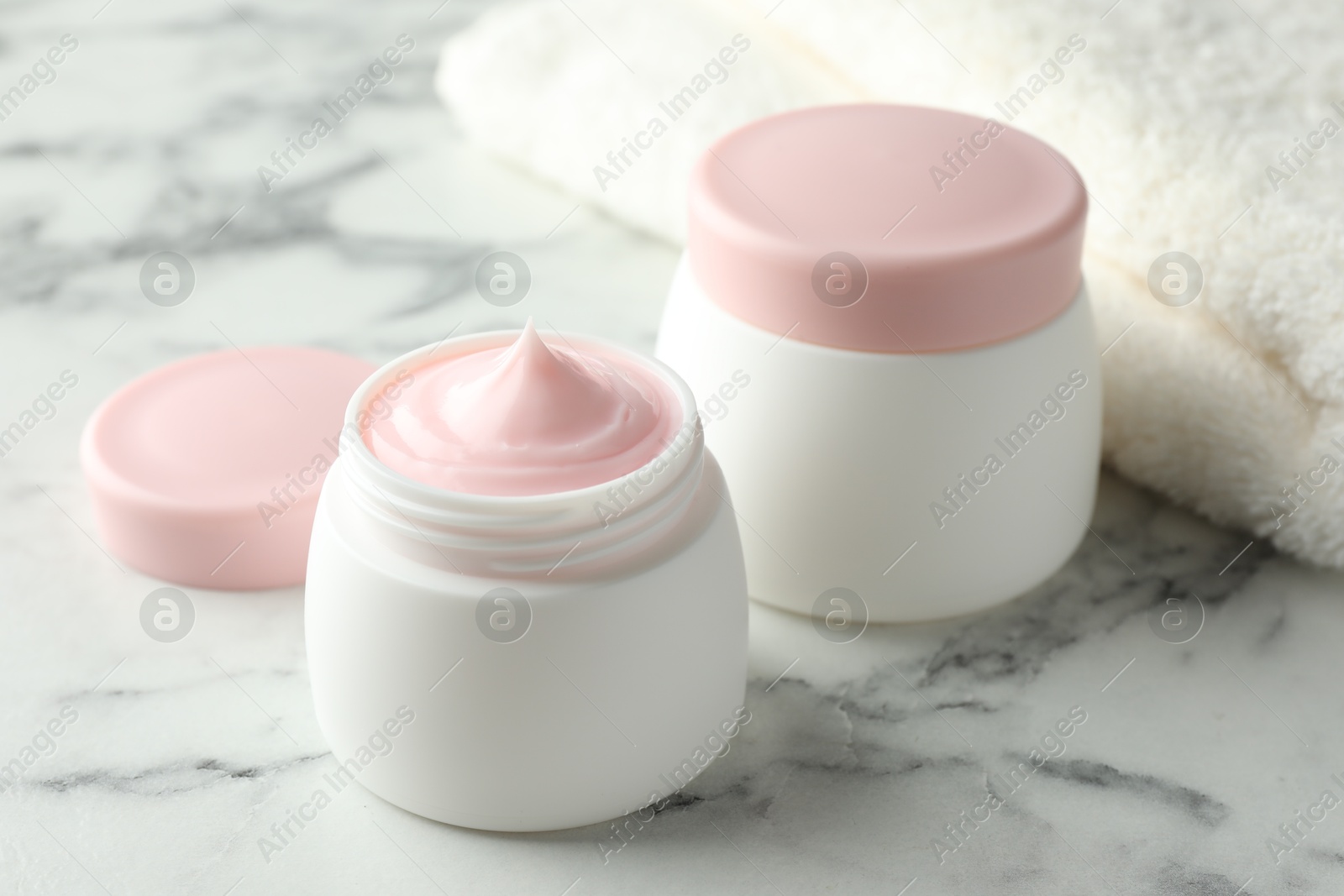 Jar of moisturizing body cream on white marble table, closeup Photo of Jar of moisturizing body cream on white marble table, closeup