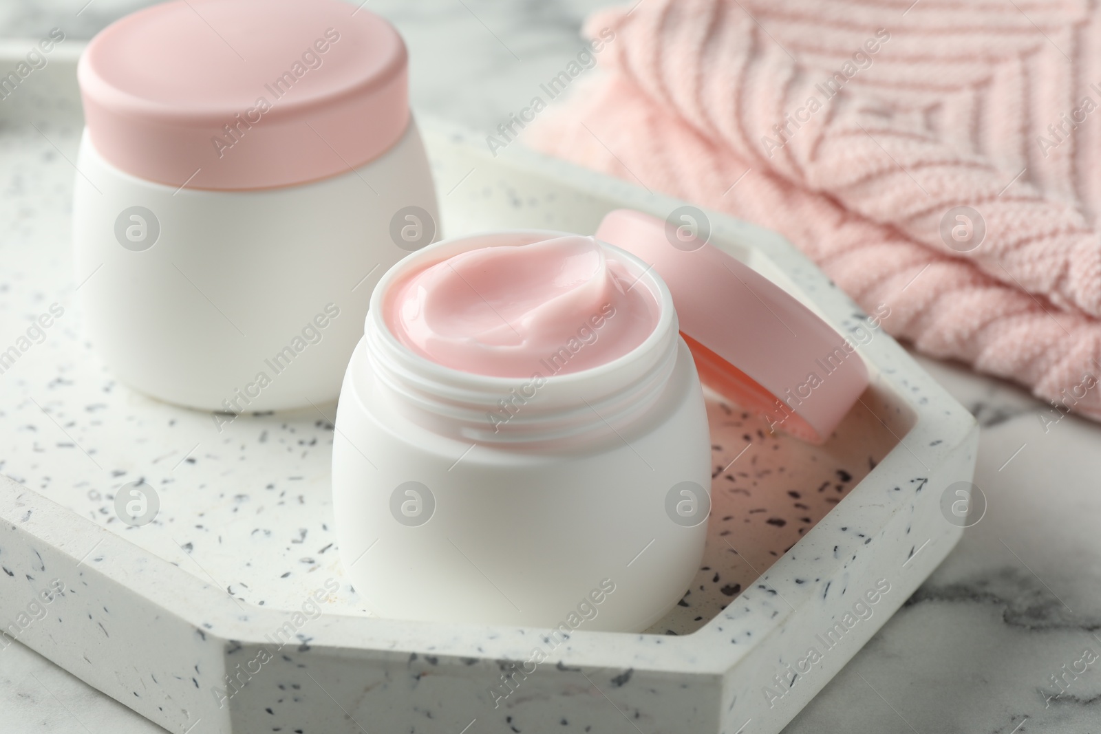Jar of moisturizing body cream on white marble table, closeup Photo of Jar of moisturizing body cream on white marble table, closeup