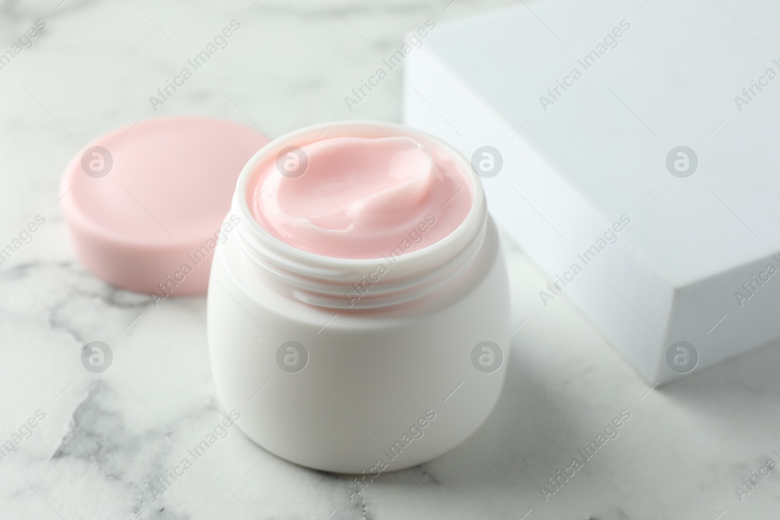 Jar of moisturizing body cream on white marble table, closeup Photo of Jar of moisturizing body cream on white marble table, closeup