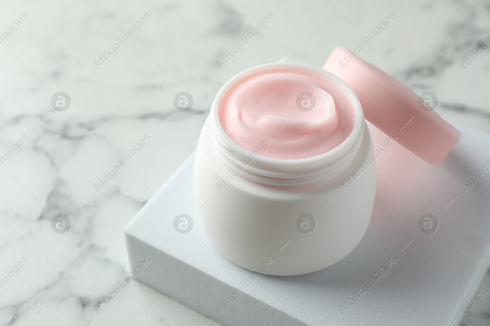 Jar of moisturizing body cream on white marble table, closeup. Space for text Photo of Jar of moisturizing body cream on white marble table, closeup. Space for text