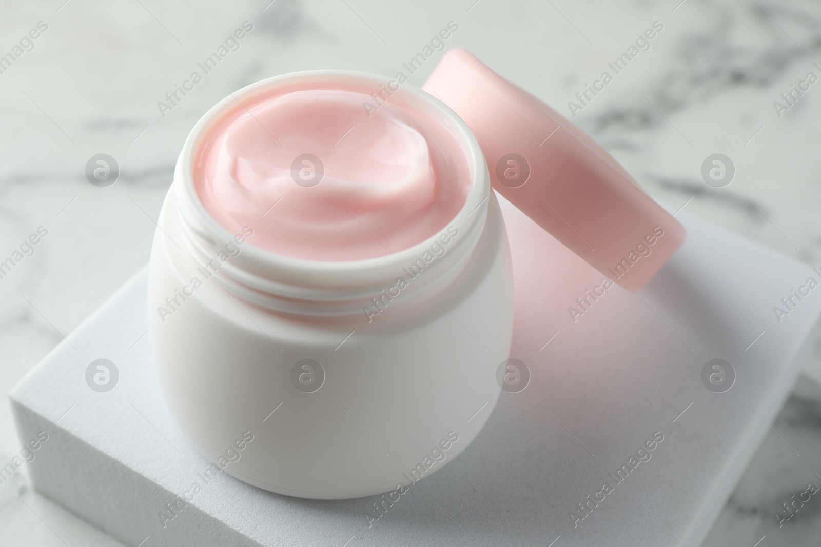 Jar of moisturizing body cream on white marble table, closeup Photo of Jar of moisturizing body cream on white marble table, closeup