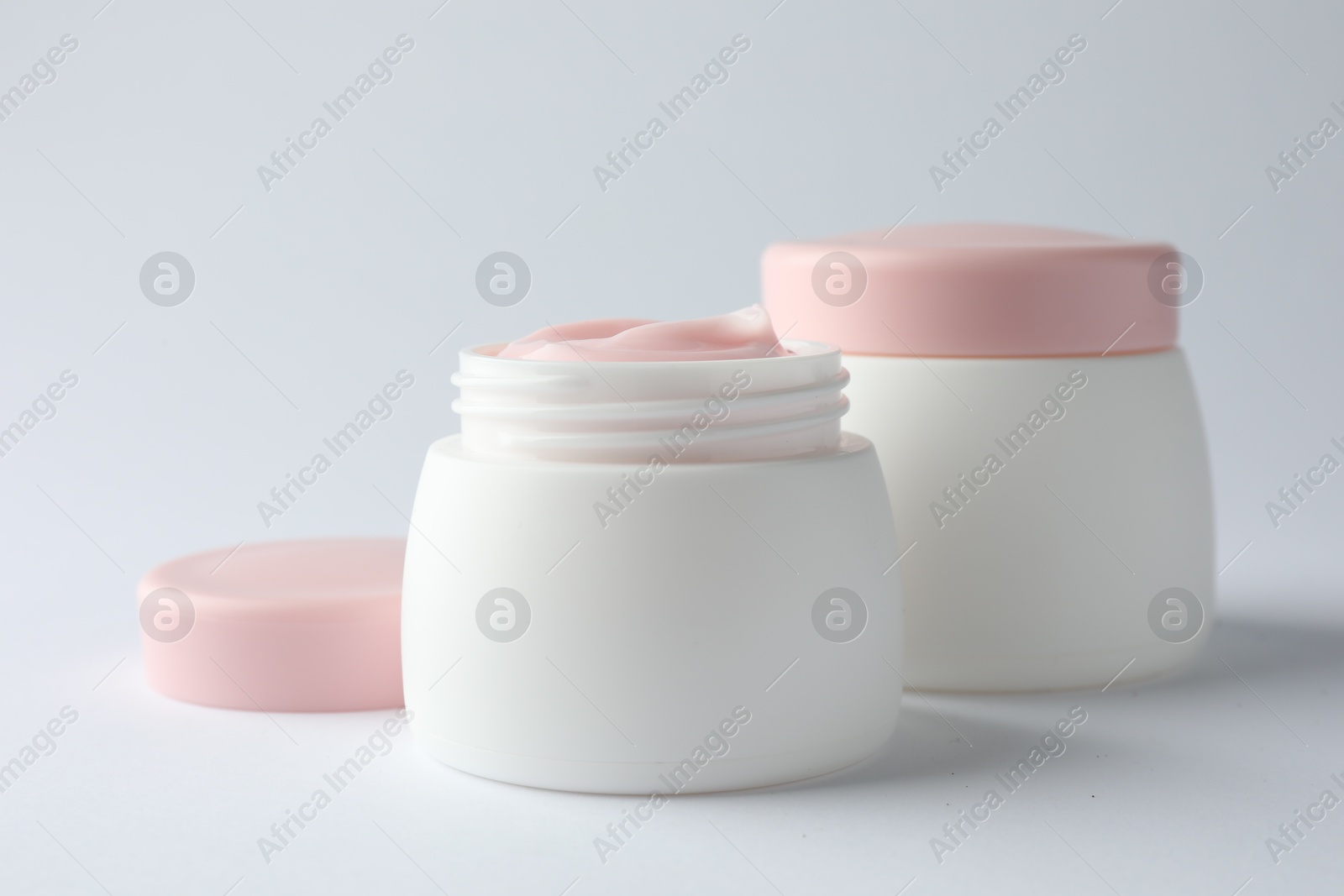 Jars of moisturizing body cream on white background, closeup Photo of Jars of moisturizing body cream on white background, closeup