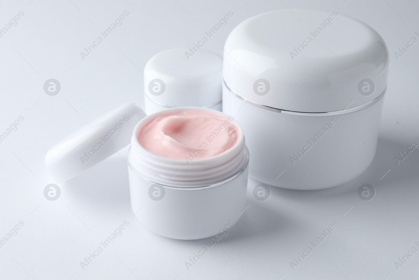 Jars of moisturizing body cream on white background, closeup Photo of Jars of moisturizing body cream on white background, closeup
