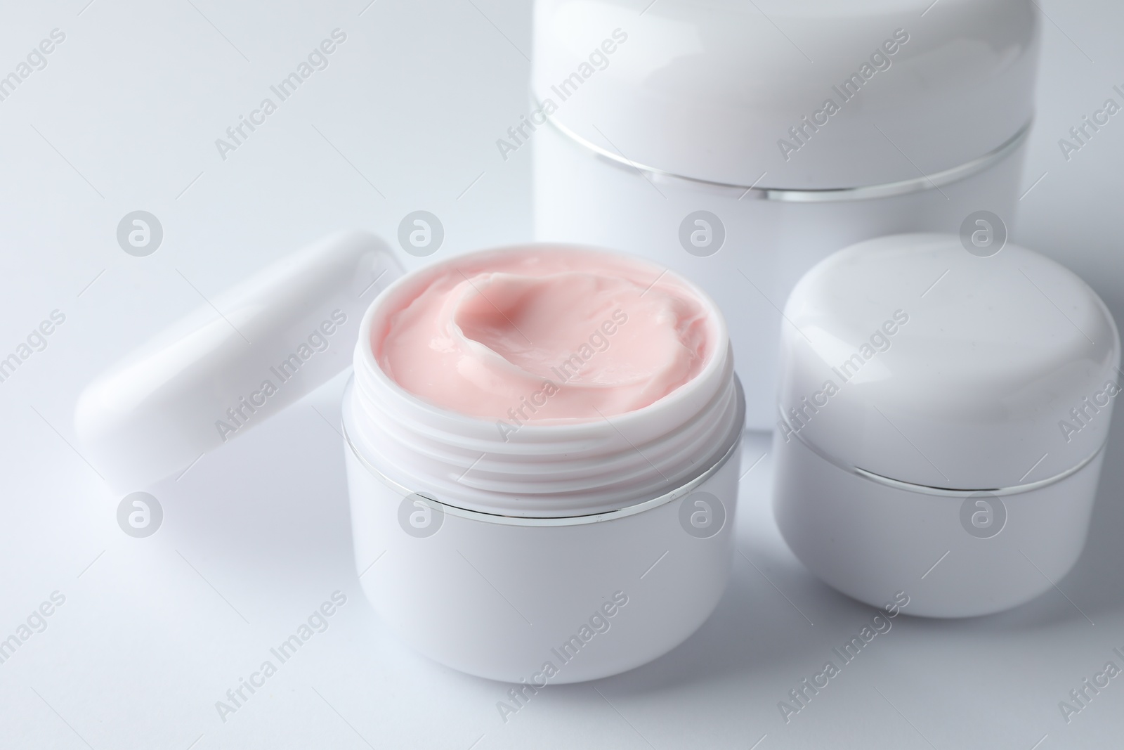Jars of moisturizing body cream on white background, closeup Photo of Jars of moisturizing body cream on white background, closeup