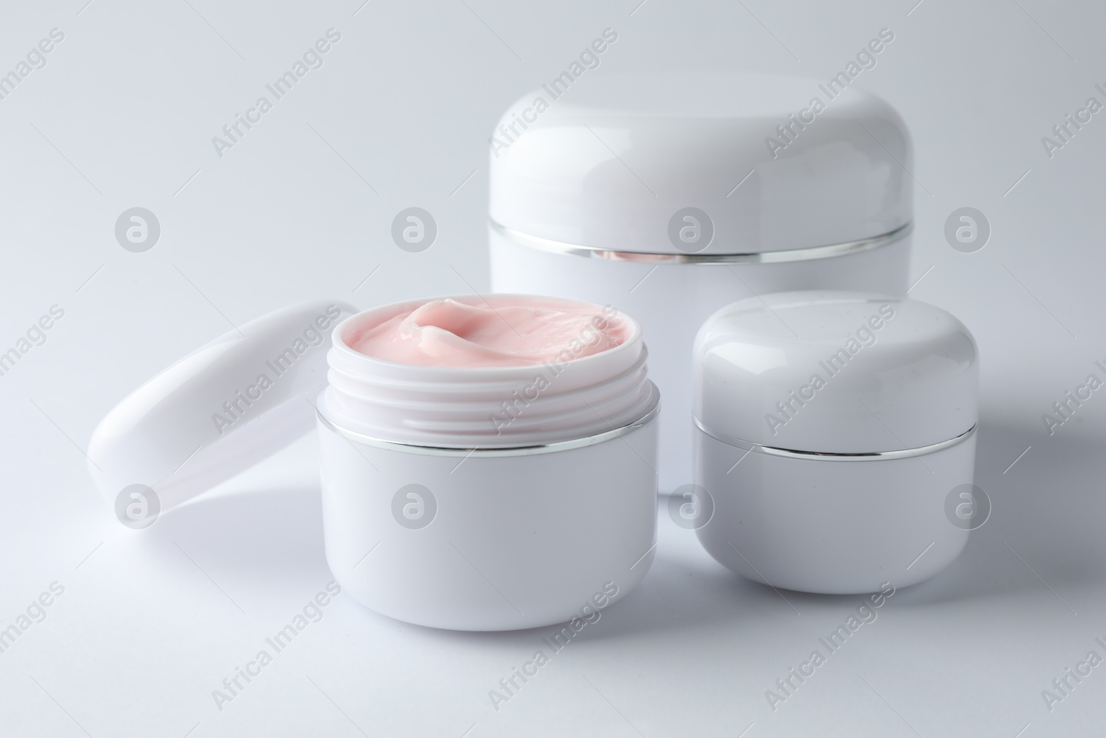 Jars of moisturizing body cream on white background, closeup Photo of Jars of moisturizing body cream on white background, closeup