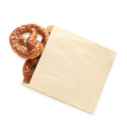 Photo of Tasty pretzels with salt in paper package isolated on white, top view