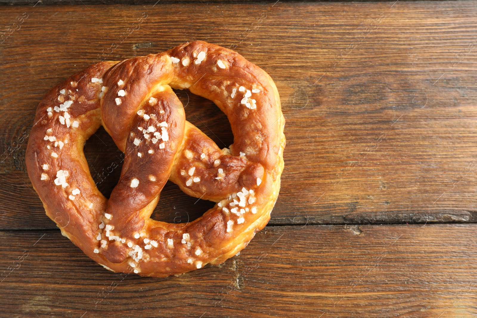 Tasty pretzel with salt on wooden table, top view. Space for text Photo of Tasty pretzel with salt on wooden table, top view. Space for text