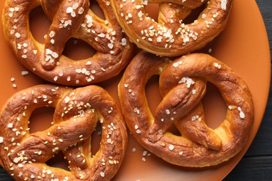 Photo of Tasty pretzels with salt on table, top view