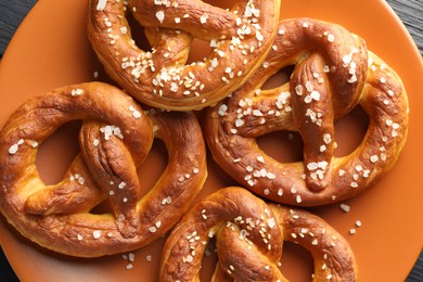 Photo of Tasty pretzels with salt on table, top view