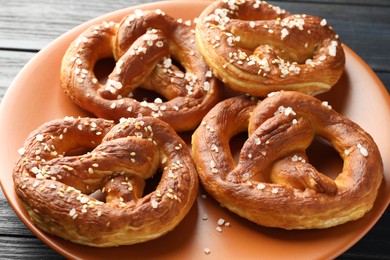Photo of Tasty pretzels with salt on table, closeup