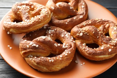 Photo of Tasty pretzels with salt on table, closeup