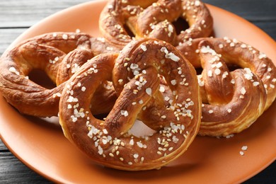 Photo of Tasty pretzels with salt on table, closeup